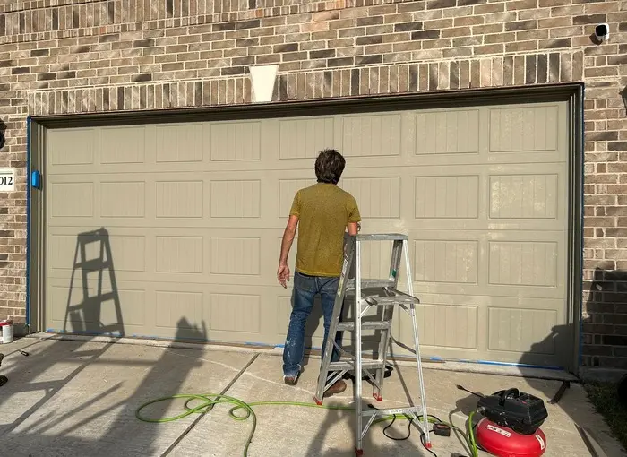 Technician inspecting a residential garage door during a service visit for a garage door repair cost guide.