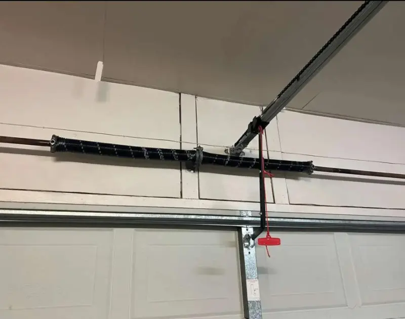 Garage Door Spring Repair Cost Odessa, TX: Freshly installed double torsion spring system positioned horizontally above a white residential garage door.
