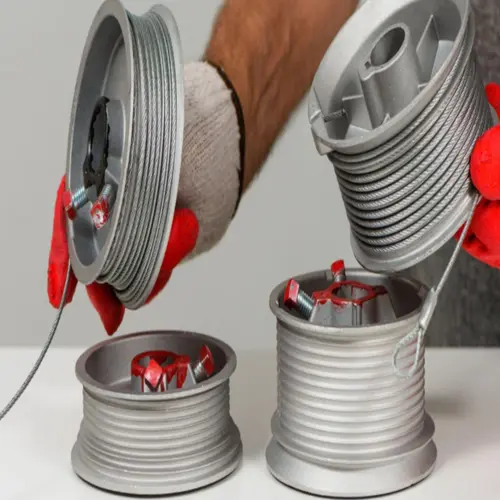 A pair of brand-new aluminum garage door cable drums wrapped with heavy-duty replacement steel cables, ready for installation in Odessa, Texas.