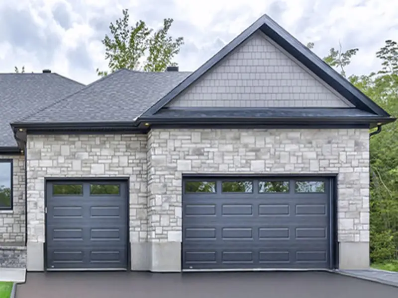A brand new, modern residential garage door perfectly installed on a beautiful suburban home.