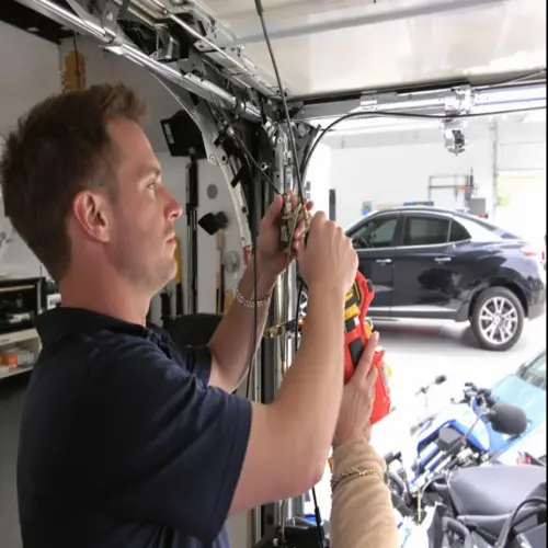 A professional garage door technician using specialized tools to replace broken cables and calibrate the overhead door system inside a residential garage.ANd showing garage door cable replacement cost.
