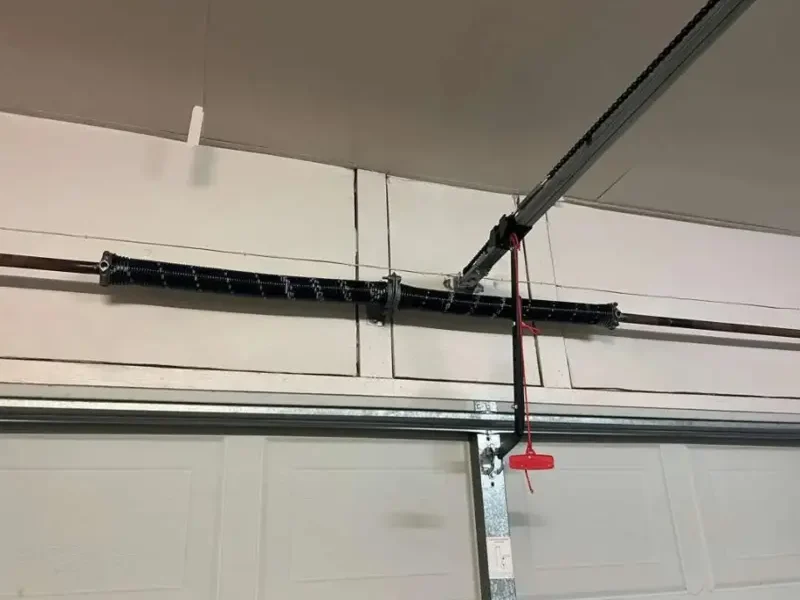 Garage Door Spring Repair Cost Odessa, TX: Freshly installed double torsion spring system positioned horizontally above a white residential garage door.
