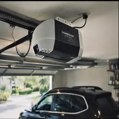 A modern black and white Chamberlain smart belt drive garage door opener installed on a residential garage ceiling above a parked SUV during a garage door opener replacement vs repair assessment in Odessa, TX.