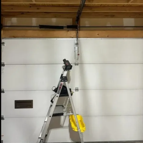 A broken garage door spring requiring professional garage door spring repair in Odessa, TX, showing why you shouldn't open a door with a snapped spring.