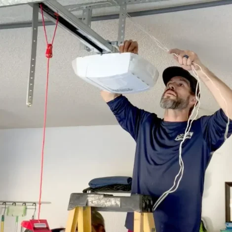 Technician adjusting a LiftMaster garage door opener during a repair service in Andrews TX